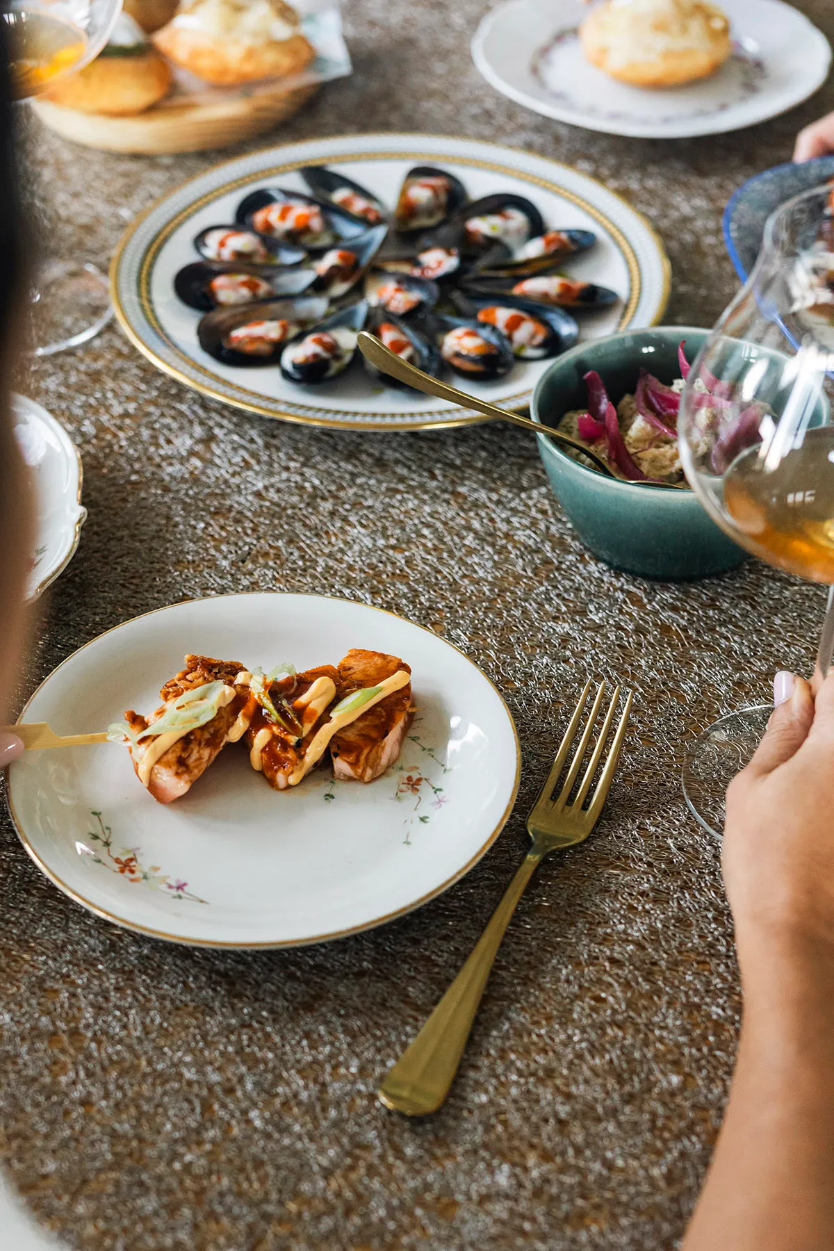 Shared table with mussels, small plates and wine