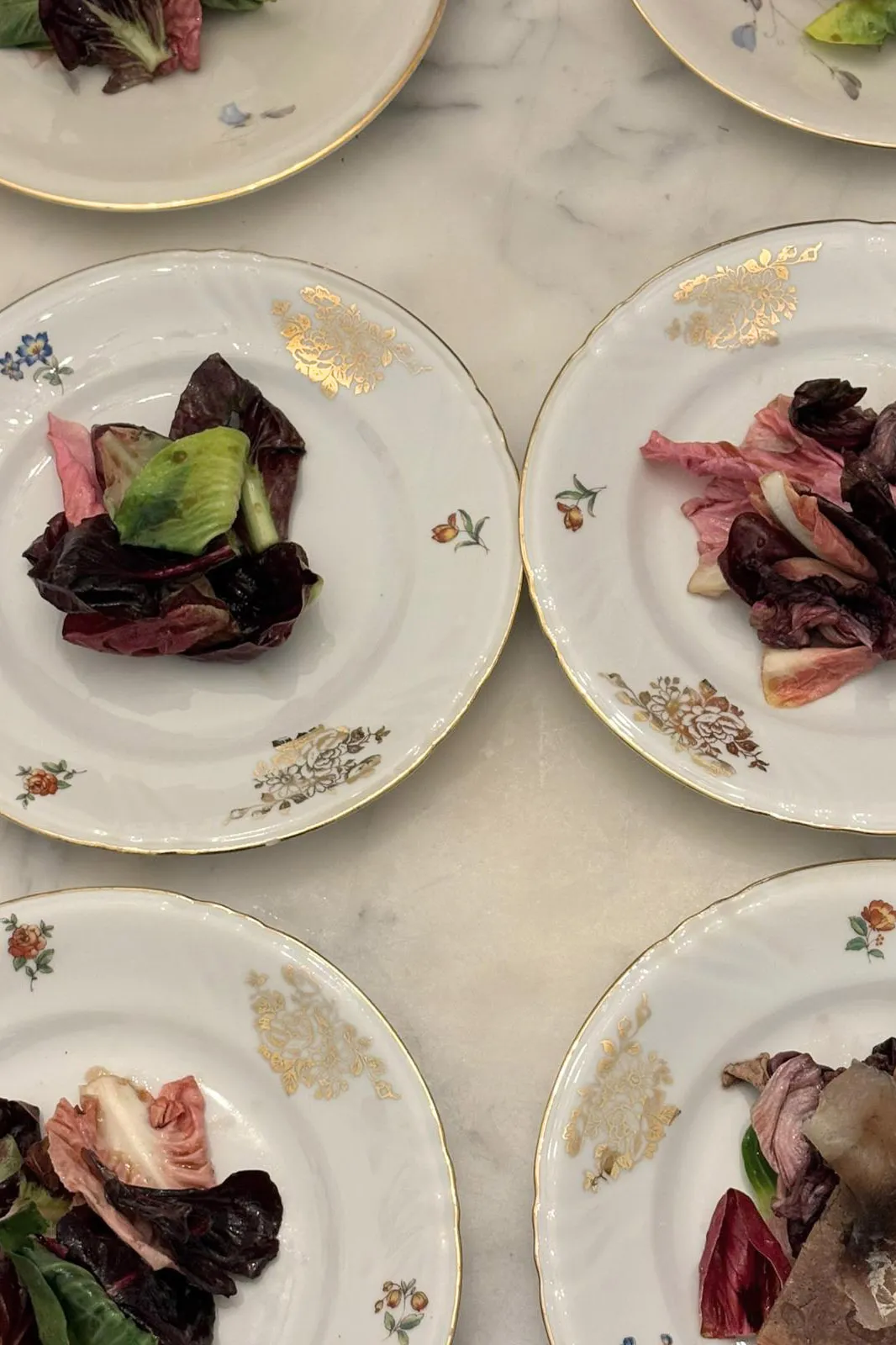 Radicchio leaves on gold-patterned porcelain plates
